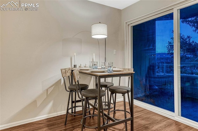 dining area with baseboards and wood finished floors