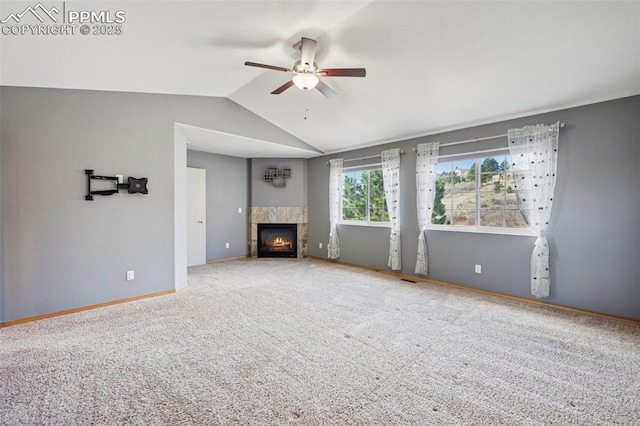 unfurnished living room featuring a tile fireplace, carpet, vaulted ceiling, a ceiling fan, and baseboards