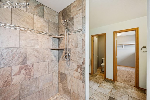 full bath with a tile shower, a spacious closet, and toilet