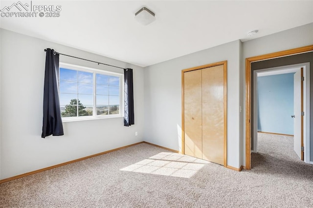 unfurnished bedroom featuring carpet floors, a closet, and baseboards