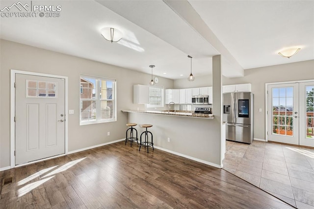 kitchen with a healthy amount of sunlight, white cabinetry, stainless steel appliances, and a sink