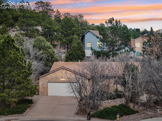5435 Setters Way, Colorado Springs, CO 80919 - obstructed view of property with concrete driveway, a garage, and brick siding