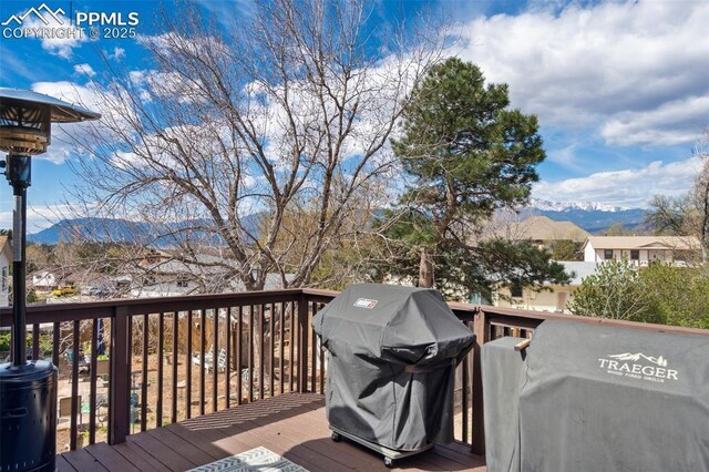 wooden terrace with a mountain view and area for grilling