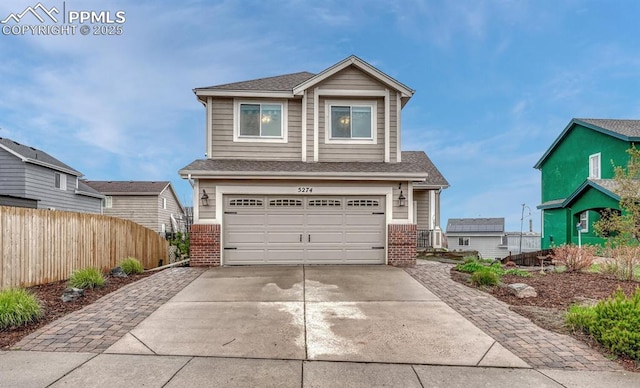 view of front of home with brick siding, an attached garage, fence, and concrete driveway
