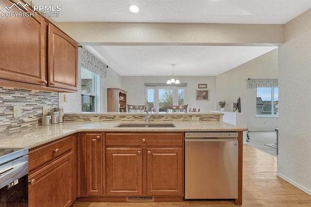 kitchen featuring dishwasher, a sink, a peninsula, brown cabinets, and light stone countertops