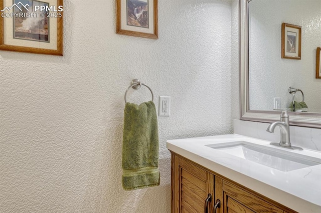 bathroom featuring vanity and a textured wall