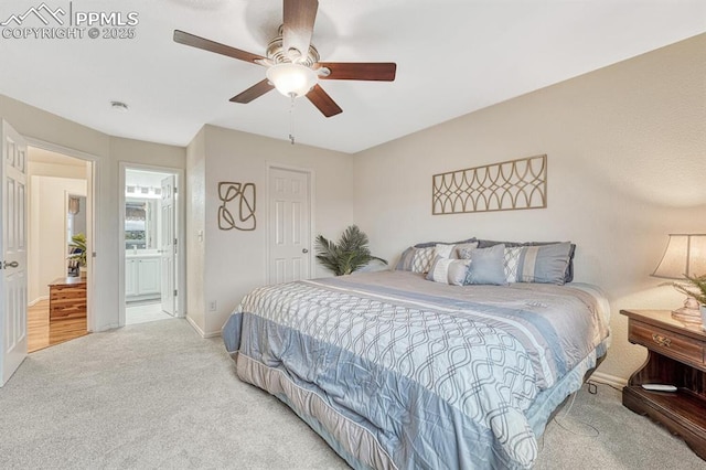 carpeted bedroom featuring baseboards, ceiling fan, and ensuite bath