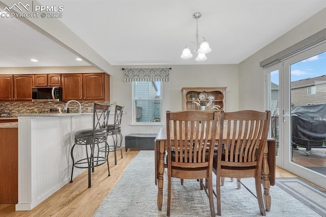 dining area featuring healthy amount of natural light, a chandelier, light wood-style flooring, and recessed lighting