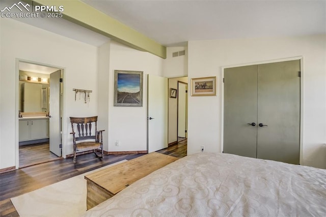 bedroom featuring beam ceiling, connected bathroom, a closet, visible vents, and wood finished floors