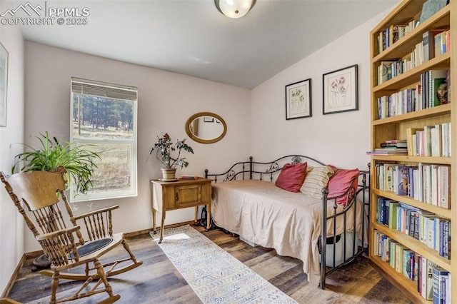 bedroom with wood finished floors and vaulted ceiling