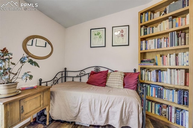 bedroom featuring lofted ceiling and wood finished floors
