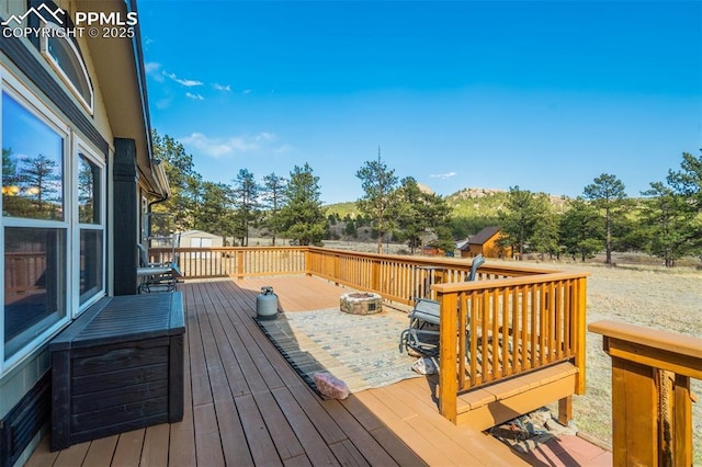 wooden deck featuring a storage shed and an outbuilding