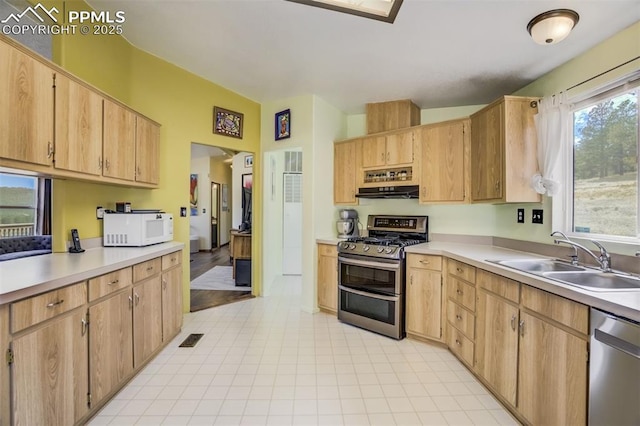 kitchen with a sink, visible vents, stainless steel appliances, light countertops, and under cabinet range hood