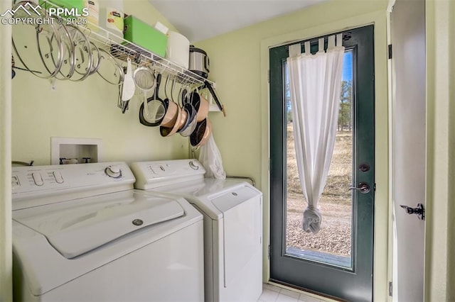 laundry area featuring light tile patterned floors, laundry area, and washer and clothes dryer