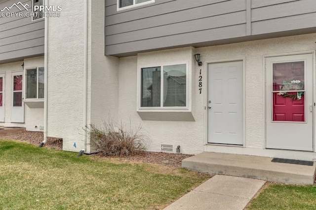 1287 Soaring Eagle Dr, Colorado Springs, CO 80915 - property entrance featuring stucco siding, crawl space, and a lawn