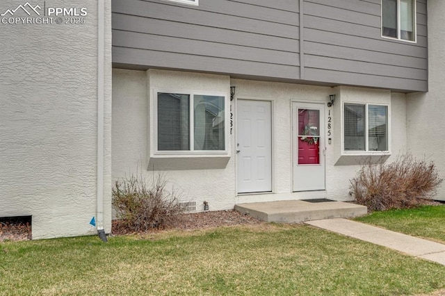 1287 Soaring Eagle Dr, Colorado Springs, CO 80915 - property entrance featuring stucco siding and a lawn