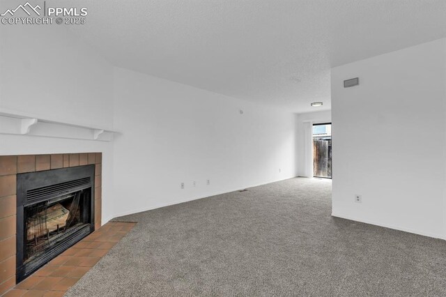 1287 Soaring Eagle Dr, Colorado Springs, CO 80915 - unfurnished living room featuring a tiled fireplace, carpet floors, and visible vents