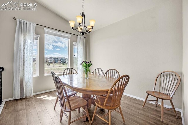8421 Crooked Branch Ln, Colorado Springs, CO 80927 - dining room with wood finished floors, baseboards, lofted ceiling, and a chandelier