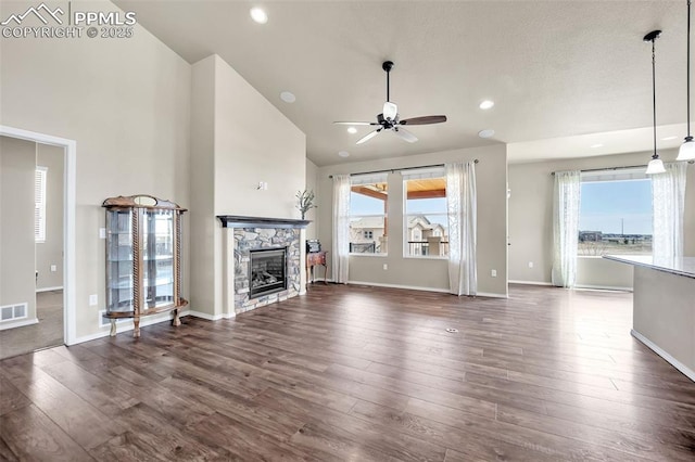 8421 Crooked Branch Ln, Colorado Springs, CO 80927 - unfurnished living room featuring plenty of natural light, ceiling fan, dark wood-style floors, and a stone fireplace