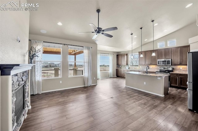 8421 Crooked Branch Ln, Colorado Springs, CO 80927 - kitchen featuring a sink, a center island with sink, tasteful backsplash, a ceiling fan, and appliances with stainless steel finishes