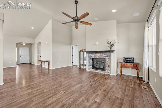 8421 Crooked Branch Ln, Colorado Springs, CO 80927 - unfurnished living room with visible vents, wood finished floors, a fireplace, ceiling fan, and high vaulted ceiling