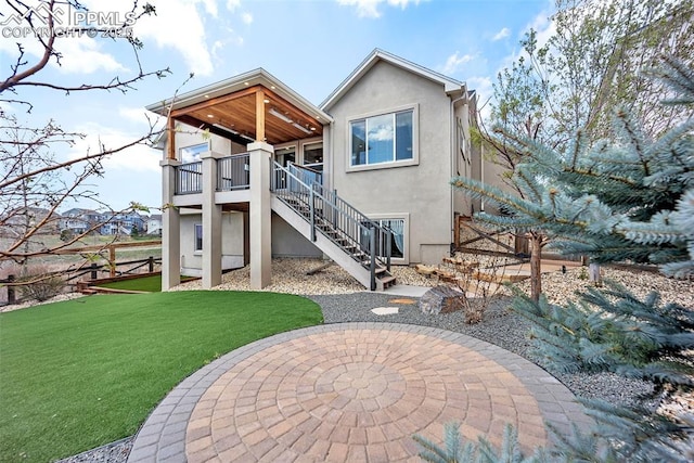 8421 Crooked Branch Ln, Colorado Springs, CO 80927 - rear view of property featuring stairs, stucco siding, a yard, and a patio