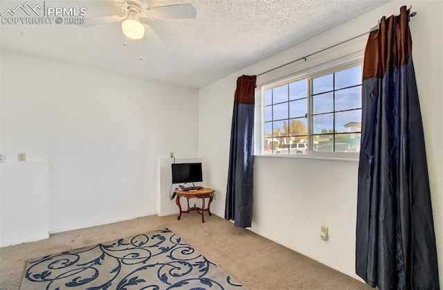 interior space featuring a textured ceiling, a ceiling fan, and light carpet