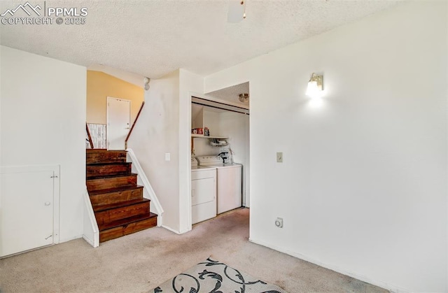 interior space with a textured ceiling, washer and dryer, stairs, and light carpet