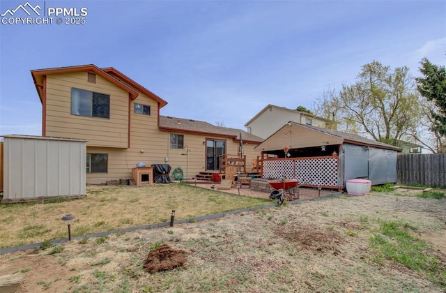rear view of property with fence, a shed, an outbuilding, and a yard