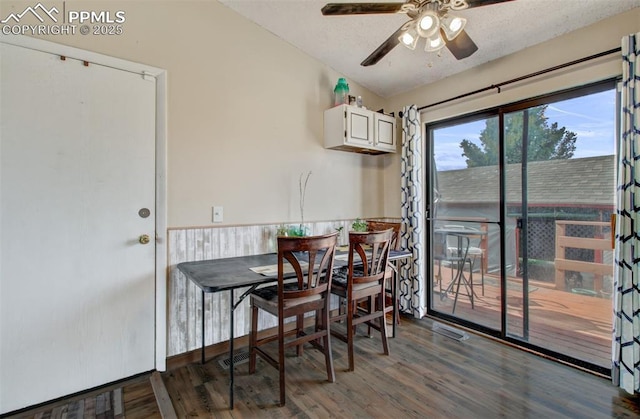 dining space with a ceiling fan, visible vents, wood finished floors, and a textured ceiling