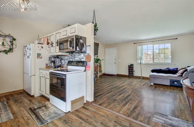 kitchen with open floor plan, wood finished floors, white appliances, and baseboards
