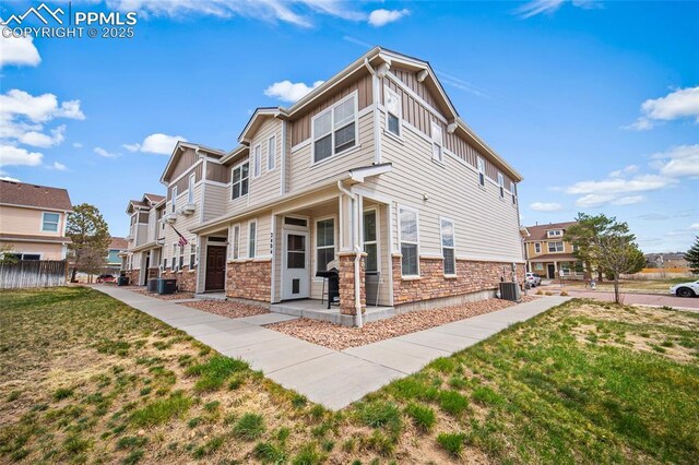 2404 Obsidian Forest Vw, Colorado Springs, CO 80951 - exterior space featuring central AC, board and batten siding, a lawn, and stone siding