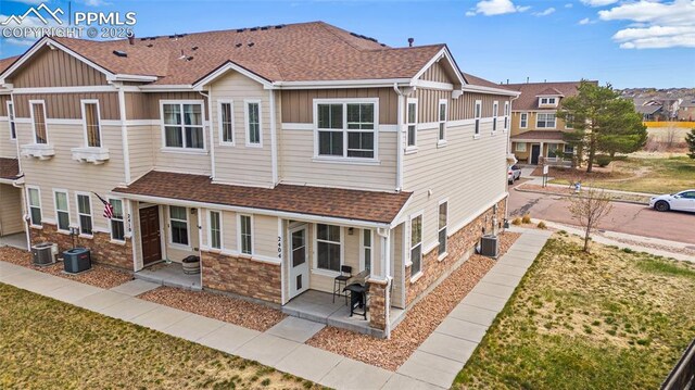 2404 Obsidian Forest Vw, Colorado Springs, CO 80951 - townhome / multi-family property with a shingled roof, board and batten siding, central air condition unit, and stone siding