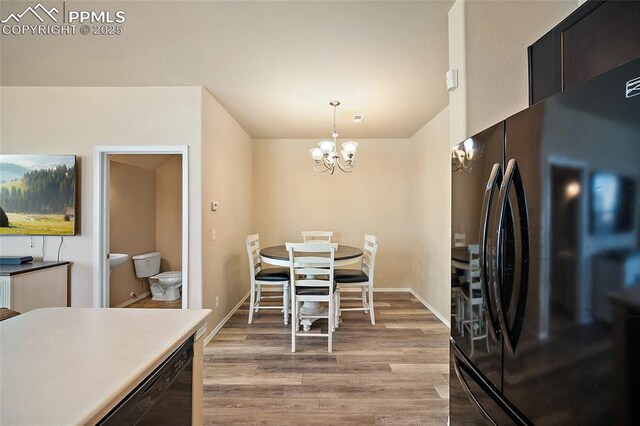 2404 Obsidian Forest Vw, Colorado Springs, CO 80951 - kitchen featuring a chandelier, baseboards, light wood-style flooring, pendant lighting, and freestanding refrigerator