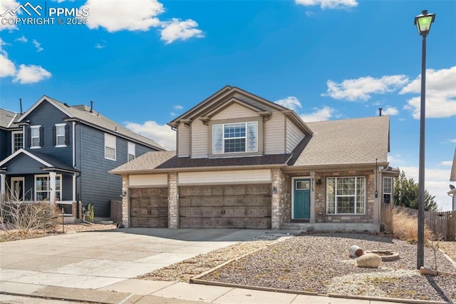 traditional-style home with concrete driveway, fence, roof with shingles, and a garage