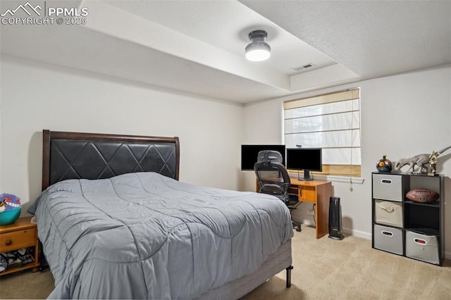 bedroom with light colored carpet, baseboards, a tray ceiling, and visible vents