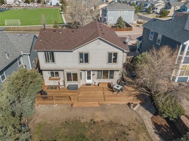 rear view of house with a wooden deck, roof with shingles, and a residential view