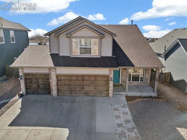 traditional-style house with stone siding, driveway, roof with shingles, and a garage