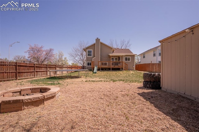 270 Wallace St, Colorado Springs, CO 80911 - view of yard featuring a wooden deck, a fenced backyard, a fire pit, and a trampoline