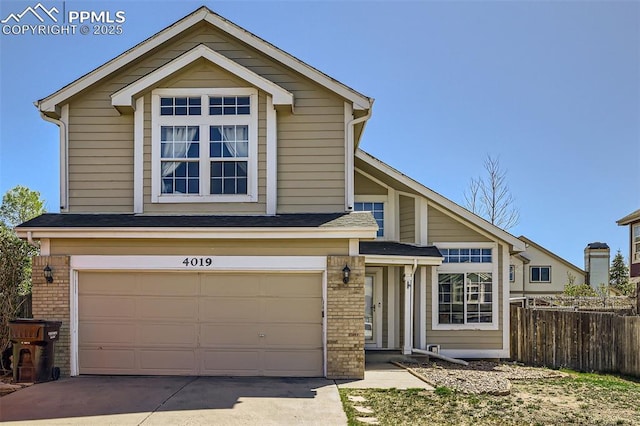 traditional-style house featuring fence, an attached garage, driveway, and brick siding