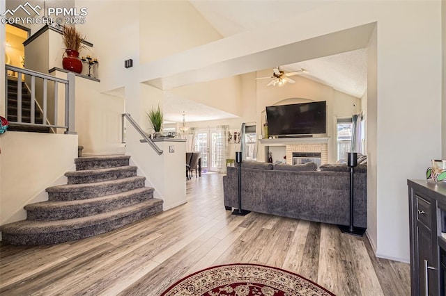 living area with baseboards, a ceiling fan, stairs, and wood finished floors