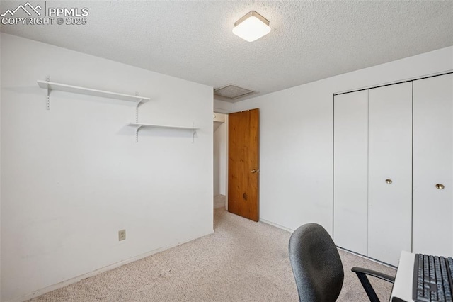 office space with a textured ceiling and light colored carpet