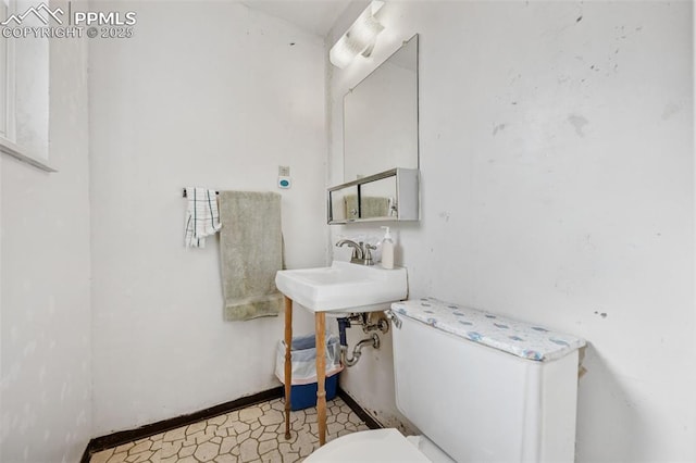 bathroom featuring toilet, tile patterned floors, and a sink