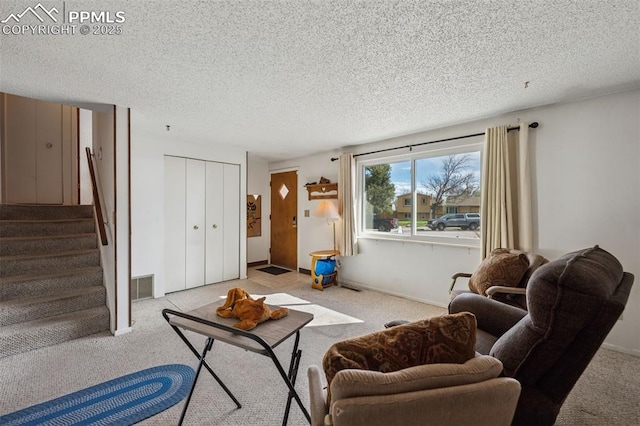 carpeted living room with stairs, visible vents, and a textured ceiling