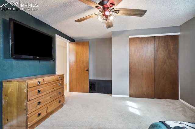 bedroom featuring a textured ceiling, baseboards, carpet, a closet, and ceiling fan
