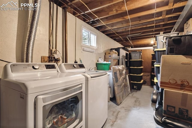 laundry room with a textured wall, separate washer and dryer, and laundry area