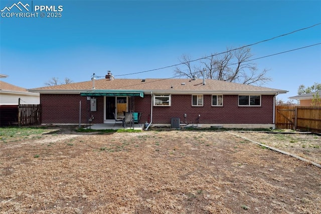back of property with brick siding, central AC unit, fence, and a patio area