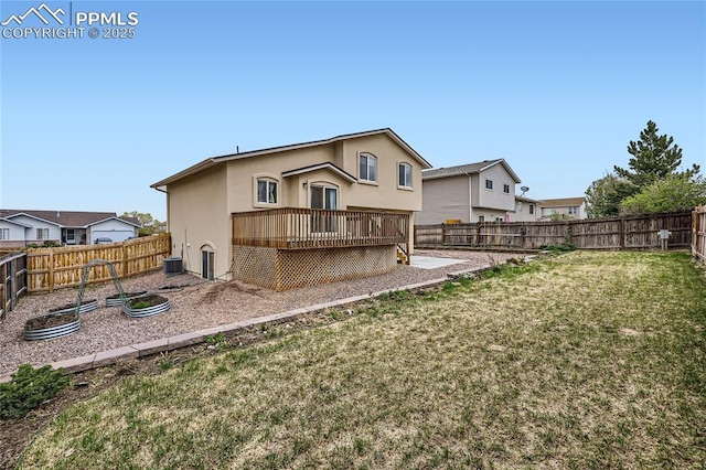 rear view of property featuring a deck, a yard, stucco siding, and a fenced backyard