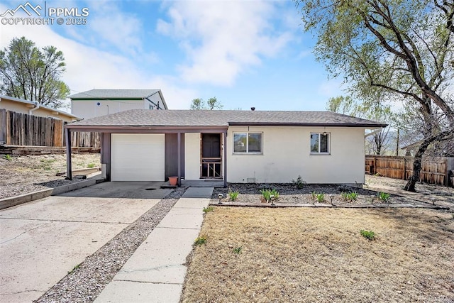 627 E Las Animas St, Colorado Springs, CO 80903 - view of front facade featuring driveway, fence, a garage, stucco siding, and roof with shingles