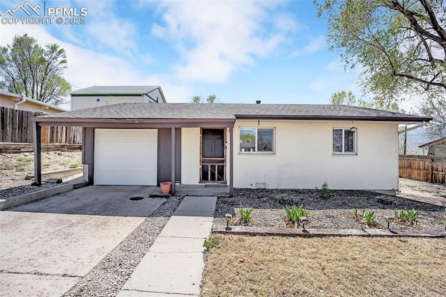 627 E Las Animas St, Colorado Springs, CO 80903 - view of front facade with driveway, fence, an attached garage, a shingled roof, and stucco siding